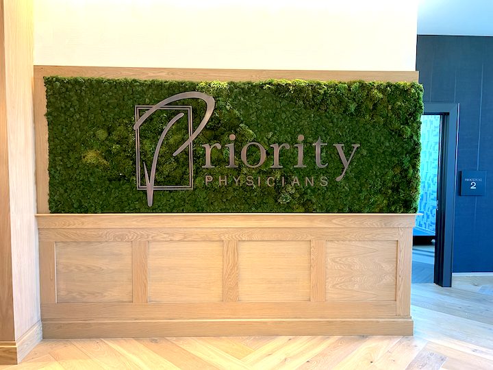 Priority Physicians logo surrounded by green moss